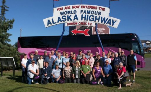 Contact us to be in a group like this one in front of a Nagel Coach at Alaska HIghway Mile 0